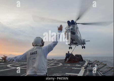 160627-N-WM647-386 MER DES PHILIPPINES (27 juin 2016) Premier maître de Manœuvre principal David Golden des signaux à un SA-330J Puma hélicoptère sur le pont d'envol de la classe Arleigh Burke destroyer lance-missiles USS (DDG 85) Lexington-historic district comme marins attacher les palettes vides à l'hélicoptère pendant un ravitaillement vertical en mer avec la commande de transport maritime de marchandises militaires et munitions ship USNS Matthew Perry (T-AKE 9). Est Lexington-historic District en patrouille avec le groupe aéronaval du cinq (5) CSG dans la 7e Flotte des États-Unis à l'appui de la zone de responsabilité de la sécurité et de la stabilité dans l'Indo-Asia-Pacifique. (U.S. Photo b marine Banque D'Images