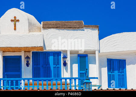 Maison de style grec traditionnel, avec des volets bleus et croix chrétienne sur le mur, Ayia Napa, Chypre Banque D'Images