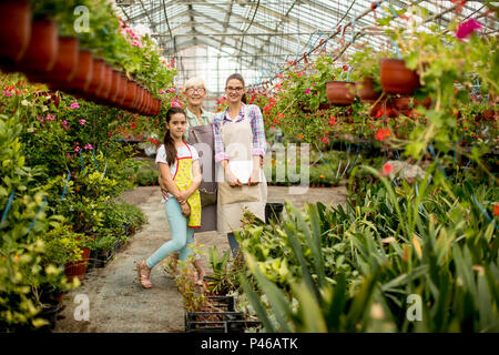 Petite fille, jeune femme et senior femme debout dans le jardin de fleurs Banque D'Images