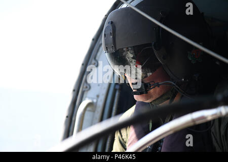 Maître de 2e classe Justin Lawrence, un technicien de maintenance de l'aviation à la Air Station Elizabeth City, N.C., se prépare pour un vol à bord d'un hélicoptère Jayhawk MH-60 Juin 13, 2016. Lawrence est un mécanicien de vol responsable de l'exécution le palan qui soulève et abaisse les gens à eux, de l'hélicoptère. (U.S. Photo de la Garde côtière par Auxiliarist David Lau) Banque D'Images