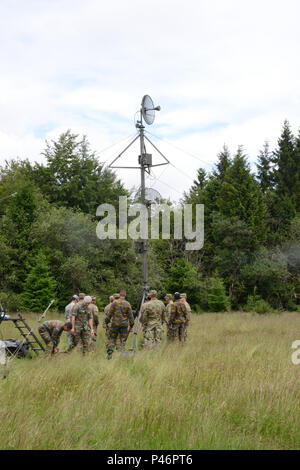 Soldats belges de 6e Groupe CIS (Communication et Systèmes d'information) faire des ajustements à un four micro-ondes de l'armée belge, à la tour de liaison à l'aide d'un four micro-ondes tactique américaine tower installé par les soldats américains de la 39e et 44e Bataillon du signal signal Bataillon expéditionnaire tactique (basé sur Grafenwoehr, Allemagne). Saint Hubert, Belgique, le 28 juin 2016. Le 39e Bataillon du signal basée à Chièvres Belgique a développé un partenariat durable avec l'armée belge 6e Groupe CIS en menant des exercices combinés de la formation et de la communication. Les deux unités travaillent ensemble et explorer chall technique Banque D'Images