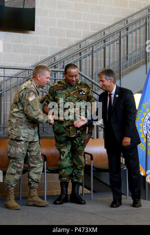 Le général de l'armée américaine Tim Reisch, adjudant général de la Garde nationale du Dakota du Sud, à gauche, le Colonel Adolf Jardim, commandant adjoint de la Force de défense du Suriname et a pris sa retraite, le colonel de l'armée américaine Tracy s'installer, la première SDNG directeur de la Programme de partenariat de l'État, de féliciter les uns les autres au cours de la cérémonie du 10e anniversaire du partenariat entre la Garde nationale du Dakota du Sud et le Suriname à force de défense au quartier général de la Force interarmées, Camp, rapide Rapid City, S.D. 22 Juin, 2016. Banque D'Images