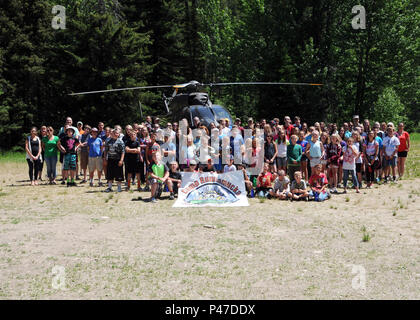 Les enfants et les membres du personnel posent pour une photo de groupe en face d'un hélicoptère de la Garde nationale du Montana en Runnamucka Camp le 29 juin 2016. La semaine de camp est conçu pour les enfants de la Garde nationale du Montana les enfants dont les parents ont déployé ou vont bientôt se déployer. Runnamucka Camp est organisé chaque année au camp Rotary situé près de Monarch, au Montana (États-Unis Photo de la Garde nationale aérienne capitaine principal Sgt. Eric Peterson) Banque D'Images