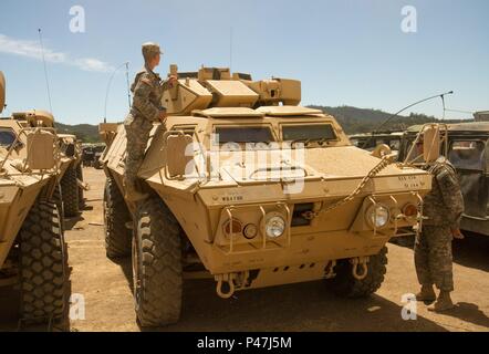 Des soldats de la réserve de l'armée américaine de la CPS. Lauren Azevdo (à gauche) et de la CPS. Hyde-Goudreau Alex de la 812e Compagnie de Police militaire hors de Orangeburg, New York regarder sur leur véhicule après l'avitaillement à Fort Hunter Liggett, Californie le 5 juin 2016. Ils sont en train de s'entraîner dans le cadre de la 91e Division de formation exercices CSTX où il effectuera la formation aux opérations de détenu. (U.S. Photo de l'Armée Le lieutenant Kevin Braafladt 1er, 91e Division de la formation aux affaires publiques.) # 91TDCSTX2016 Banque D'Images