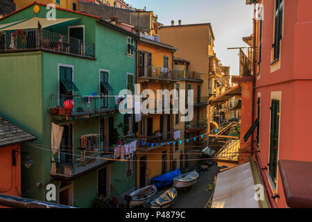 Manarola, Cinque Terre, la fin de l'après-midi paisible scène de rue avec des maisons colorées et des signes de la vie quotidienne. Banque D'Images