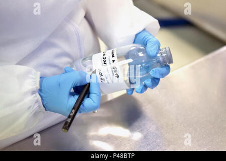 Les étiquettes des vêtements de travailleur dans une bouteille avec un échantillon dans la fabrication de produits pharmaceutiques Banque D'Images