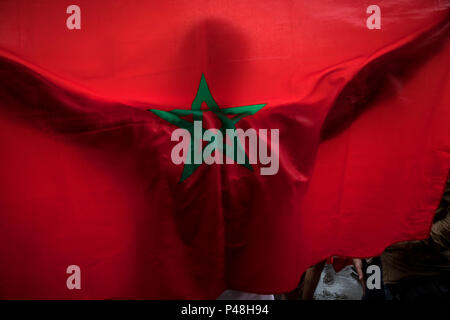 Un homme avec le drapeau national du Maroc dans une pluie Banque D'Images