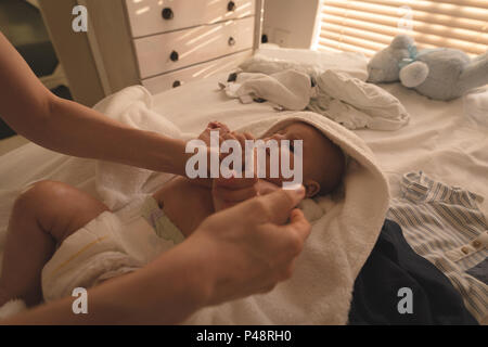 Cute baby lying on bed et mère jouer avec lui sur le lit Banque D'Images