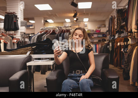 Belle femme en tenant avec selfies téléphone mobile sur la table Banque D'Images