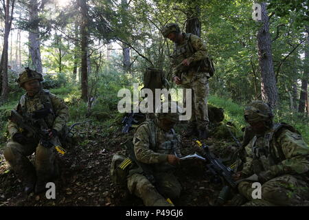 Des soldats britanniques du 2e Royal Gurkha Rifles, Brigade de Gurkhas réaliser un bref tout en menant des opérations défensives au cours de réponse rapide 16 entraînement physique à la zone d'entraînement, un Hohenfels partie de la multinationale, Centre de préparation conjointe en Allemagne, Hohenfels, Jun. 20, 2016. La réaction rapide de l'exercice est l'un des premiers événements de formation en intervention de crise militaire pour les forces aéroportées dans le monde. L'exercice est conçu pour améliorer l'état de préparation de la base de combat de la Force de réaction des Etats-Unis dans le monde - en ce moment la 82e Division aéroportée, 1ère Brigade Combat Team - pour mener Banque D'Images