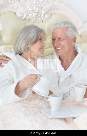 Senior couple in bed avec plateau Banque D'Images