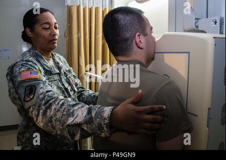 Le sergent de l'armée américaine. Tiffany M. Luciano, un Dallas, Texas, agissant comme un technicien en radiologie pour la Compagnie B, 228e de l'Hôpital de Soutien au Combat (CSH), les positions d'un patient pour une radiographie pulmonaire lors d'un examen médical de routine au Brigadier général Crawford F. Sams clinique de santé de l'Armée américaine au Camp Zama, au Japon, le 8 juin 2016. Luciano et sept autres soldats de réserve de l'Armée de l'HCS 228e sont arrivés au Japon le 4 juin pour entreprendre une mission de trois semaines afin d'améliorer la santé du Camp Zama, readinesss et la résilience. Ces stages offrent des soldats de la réserve de l'armée dans le domaine médical, des occasions uniques d'améliorer e Banque D'Images