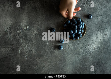 Les mains tenant Blueberrys rustique sur fond sombre. Superfood Saine alimentation Concept. Banque D'Images