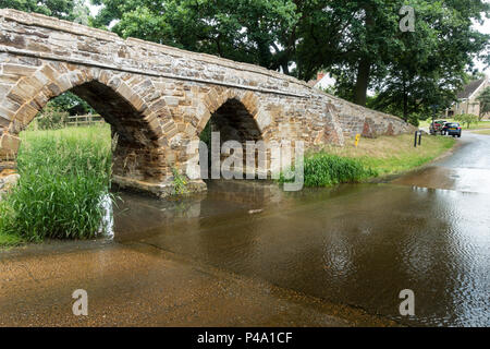 Une passerelle en pierre sur une Ford dans un village typiquement anglais en été. Sutton, Bedfordshire Banque D'Images