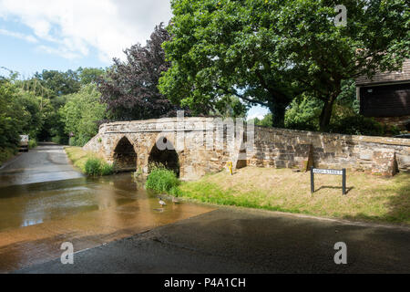 Une passerelle en pierre sur une Ford dans un village typiquement anglais en été. Sutton, Bedfordshire Banque D'Images