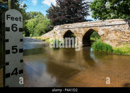 Une passerelle en pierre sur une Ford dans un village typiquement anglais en été. Sutton, Bedfordshire Banque D'Images