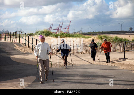 Crosby, Merseyside. Météo britannique. 21 juin 2018. Soleil, vents bleutés et nuages sur la côte pendant que les résidents actifs locaux prennent l'exercice sur le sentier côtier. Quatre femmes, un groupe de marcheurs de dame, prennent la marche nordique une forme de mobilité assistée qui peut être appréciée à la fois par les non-athlètes comme activité physique favorisant la santé. L'activité est réalisée avec des bâtons de marche spécialement conçus similaires aux bâtons de ski. Crédit: MediaWorldImages/Alay Live News Banque D'Images