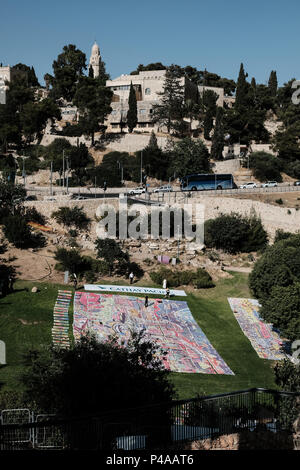 Jérusalem, Israël. 21 Juin, 2018. Un cours de yoga événement a lieu la célébration de la Journée Internationale de Yoga dans la vallée de Hinnom par la vieille ville de Jérusalem. 701 tapis de yoga, le produit de Karni Sharonna Cohen's 'le grand rêve Jérusalem 2048', puzzle, en gros œuvres à propos de l'avenir de Jérusalem, 30 ans à partir de maintenant. Banque D'Images