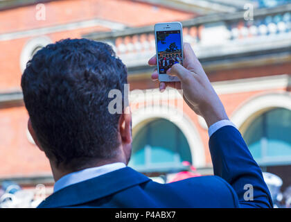 Ascot, Berkshire, Royaume-Uni. 21 juin 2018. Les Racegoers arrivent à Ascot dans leurs chapeaux et dans leur finery pour la fête des femmes à Royal Ascot pendant qu'ils se rendent à l'événement. Homme capturant l'action sur son téléphone portable. Crédit : Carolyn Jenkins/Alay Live News Banque D'Images