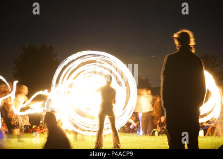 Les jongleurs de feu en gardant les spectateurs au cours de la congélation ver Solstice d'Avebury, Wiltshire nuits en UK Banque D'Images