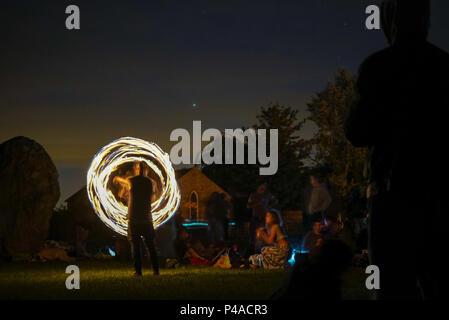 Les jongleurs de feu en gardant les spectateurs au cours de la congélation ver Solstice d'Avebury, Wiltshire nuits en UK Banque D'Images