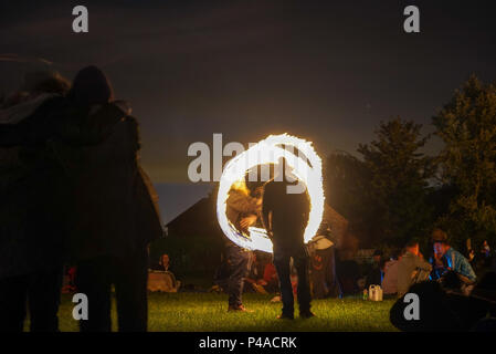 Les jongleurs de feu en gardant les spectateurs au cours de la congélation ver Solstice d'Avebury, Wiltshire nuits en UK Banque D'Images