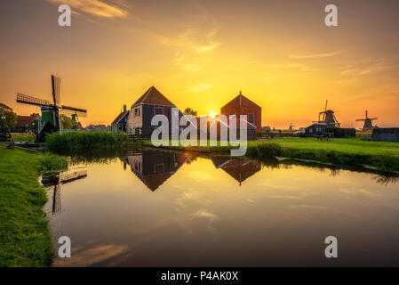 Coucher du soleil au-dessus des maisons et moulins à vent de Zaanse Schans aux Pays-Bas Banque D'Images