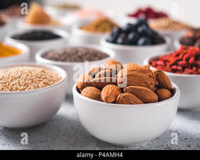 Petit bol en amande blanche et d'autres de l'air sur l'arrière-plan. Focus sélectif. De l'air différents ingrédients. Concept et illustration pour superfood et detox food Banque D'Images