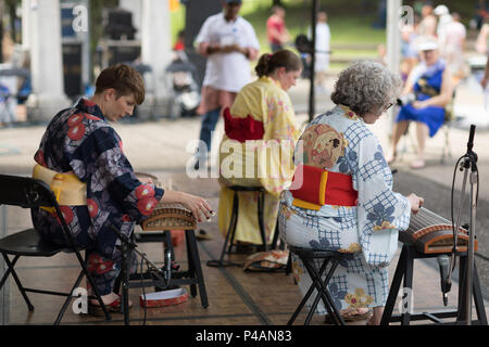 Columbus, Ohio, USA - Mai 27, 2018 trois femmes membres de la Columbus Koto Ensemble jouer le koto au festival asiatique. Banque D'Images