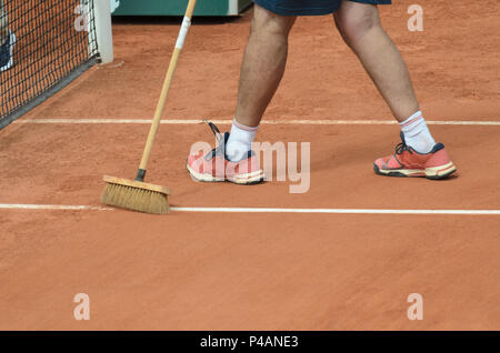 Homme nettoie, nettoyage de la ligne de tennis sur terre battue avec un balai Banque D'Images