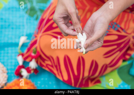 Femme préparant lei garland dans le jardin Banque D'Images