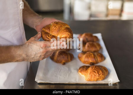 Homme baker holding croissant boulangerie Pains en boulangerie Banque D'Images