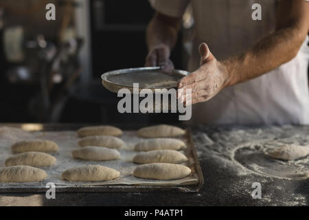 Préparer la pâte en mâle baker bakery shop Banque D'Images