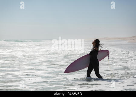 Femme debout avec surfeur surf dans la plage Banque D'Images