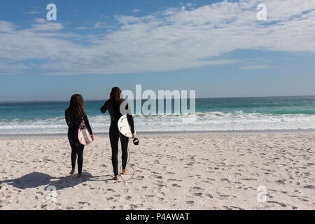 Surfer couple walking with surfboard dans la plage Banque D'Images