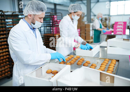 Les travailleurs de l'usine de confiserie pâtisserie mettre dans des boîtes Banque D'Images