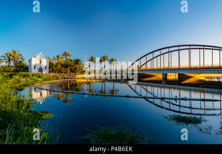 Vue d'une église avec un reflet dans l'eau et un pont sur la rivière dans la région de Valence. Valence, Espagne. Banque D'Images