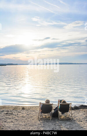 Übersee (Chiemgau), le lac de Chiemsee, plage du lido, les gens de chaises de plage, Coucher de soleil, Chiemgau, Haute-Bavière, Bavière, Allemagne Banque D'Images