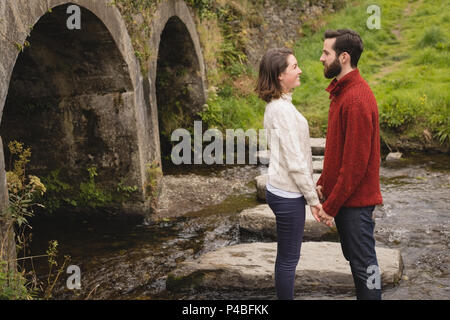 Affectionate couple standing on rock Banque D'Images