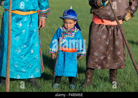 Porter robe mongole traditionnelle, un jeune garçon pridefully les peuplements avec des membres âgés de la famille, Xilinhot, Mongolie intérieure, Chine Banque D'Images