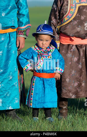 Porter robe mongole traditionnelle, un jeune garçon pridefully les peuplements avec des membres âgés de la famille, Xilinhot, Mongolie intérieure, Chine Banque D'Images