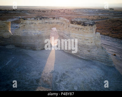 Faisceau de lumière brillant à travers une arche naturelle dans les pyramides de craie à Monument Rocks, Kansas au lever ou au coucher du soleil Banque D'Images