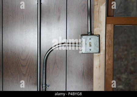 Old vintage metal interrupteur d'électricité et de la boîte de jonction avec des gaines sur la surface monté sur un mur en bois avec une porte Banque D'Images