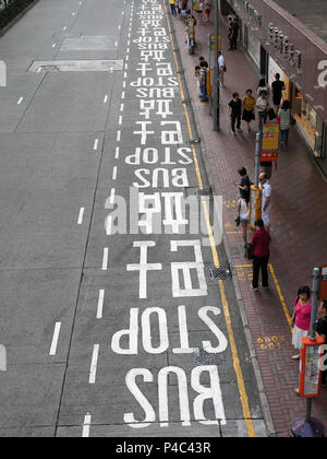 Vue d'un long couloir de bus avec une signalisation en anglais et en chinois à Hong Kong Banque D'Images
