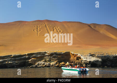 Groupe touristique dans un bateau près de candélabres des Andes dans la région de Pisco Bay, au Pérou. Candélabres est bien connu sur le géoglyphe préhistorique face nord de Banque D'Images