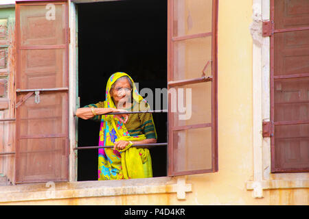 Femme regardant par la fenêtre à Jaipur, Rajasthan, Inde. Jaipur est la capitale et la plus grande ville du Rajasthan. Banque D'Images