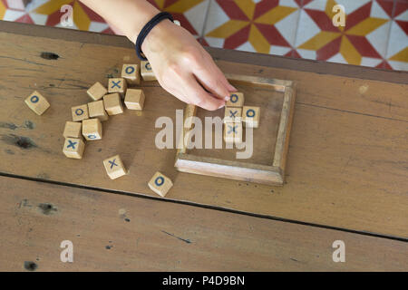 Jouet en bois jeu xo est, avec la main sur le Joueur de fond de table en bois. Banque D'Images