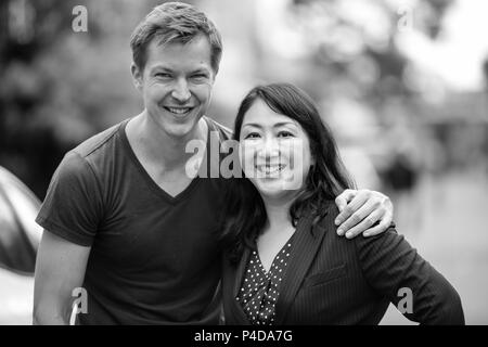 Belle mature Asian businesswoman et jeune homme scandinave ensemble dans les rues à l'extérieur en noir et blanc Banque D'Images