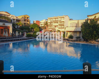 Lanzarote, Espagne - Décembre 13, 2013 : looking out to Spanish hotel chambres et piscine commune, que le soleil provoque la réflexion sur la piscine. Banque D'Images