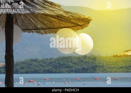 Balloons hanging on a wooden parasol sur la plage Banque D'Images